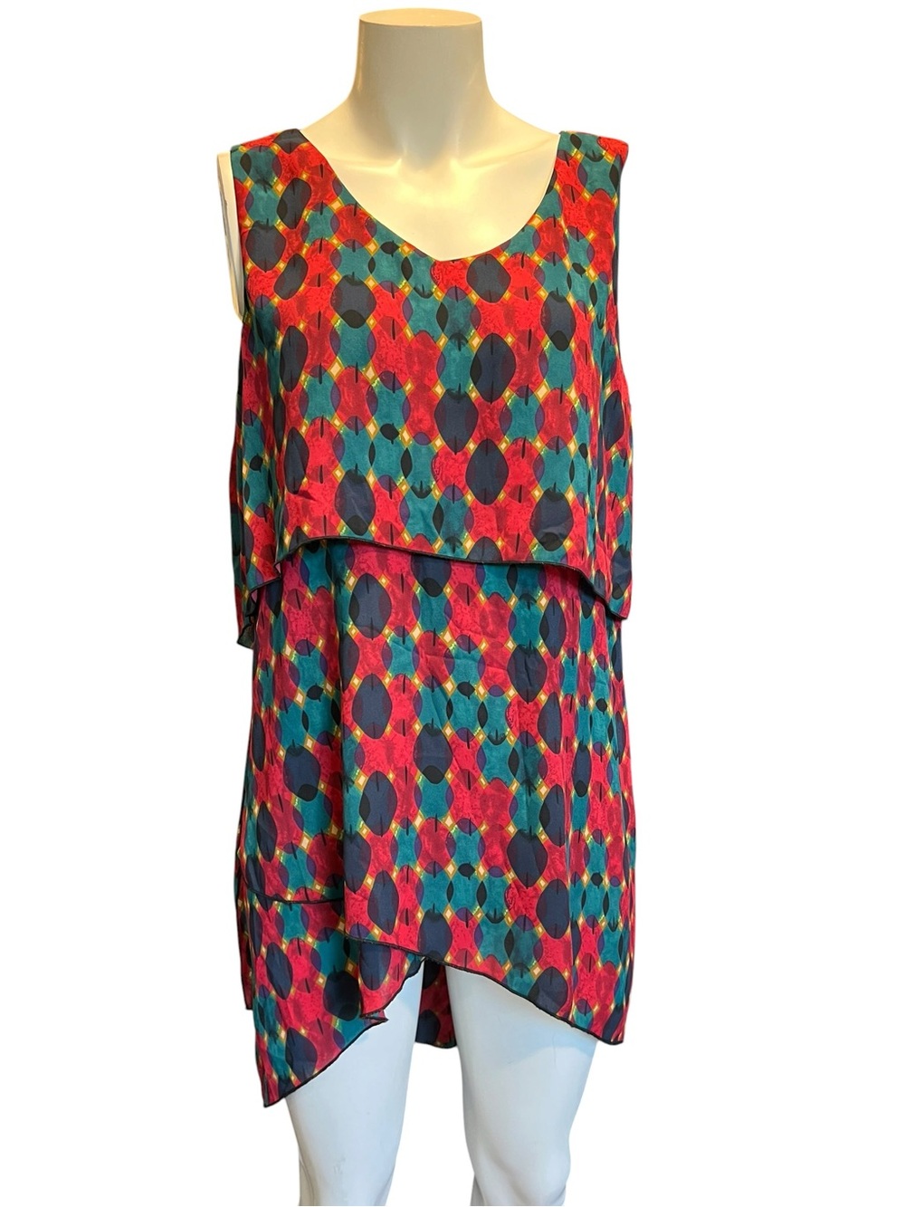 This John Mark tunic top features a vibrant multicolored geometric pattern .